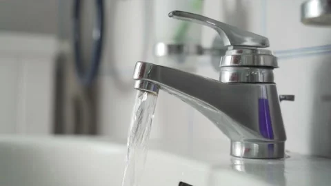 Young man opens faucet, spending lots of water, side view Stock Footage 139056904