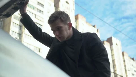 Young man opens the hood of his car. car breakdown. close-up. Stock Footage 233355376