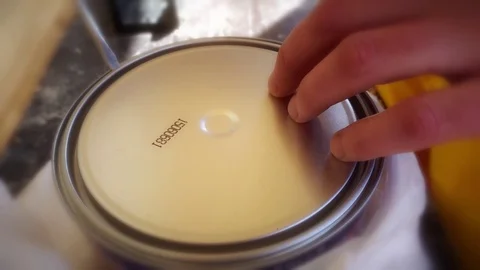 A young man opens a jar of lacquer on wood Stock Footage 75210820