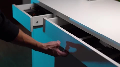 A young man opens two desk drawers containing different things Stock Footage 267100580