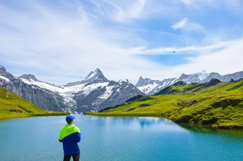 Young man operating the flying drone over beautiful Bachalpsee in the Swiss Alps Stock Photos