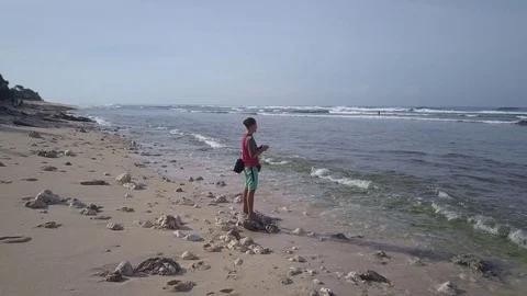 Young man operating quadcopter drone using remote control on seashore. Stock Footage 84628892