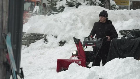 Young man operating snow blower in heavy snow Stock Footage 341981524