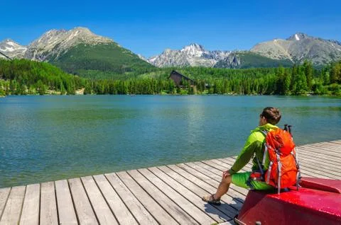 Young man with orange backpack on red boat Stock Photos