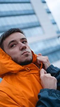 Young man in orange work uniform - glass building on background Fotos Stock
