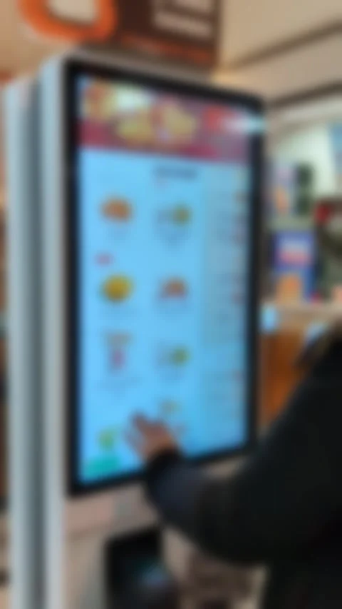 Young man ordering fast food using digital self-service kiosk Video stock 332636953