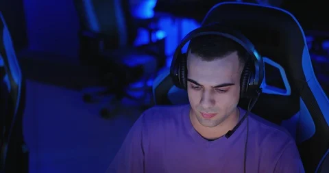 Young man with an oriental appearance sits in headphones at a computer. Man Stock Footage 126017682