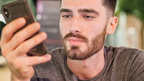 Young man outside at night using phone Stock Photos