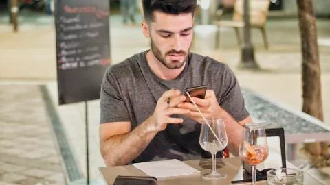 Young man outside using phone Stock Photos
