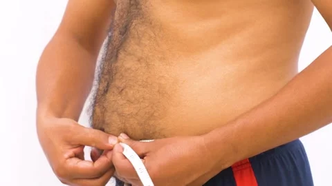 An young man with overweight abdomen measuring belly with tape. Stock Footage 272583076