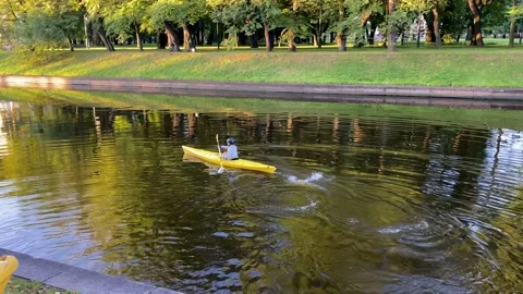 A young man with a paddle floats on a yellow kayak Stock-Footage 137621644
