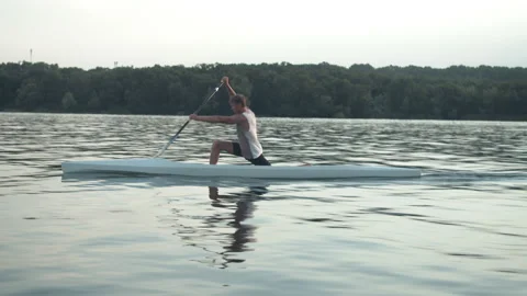 Young man paddling a canoe Stock Footage 135865813