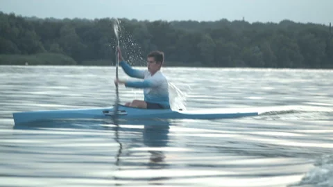 Young man paddling a kayak Stock Footage 135864512