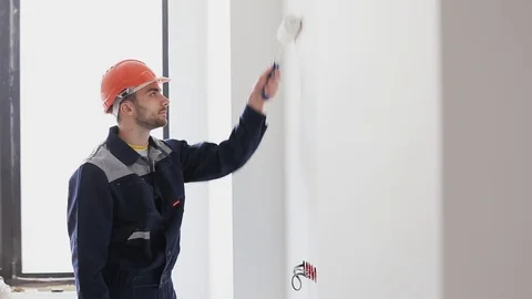 Young man paint wall in white. Brush or roller with white paint. Stock Footage 70418307