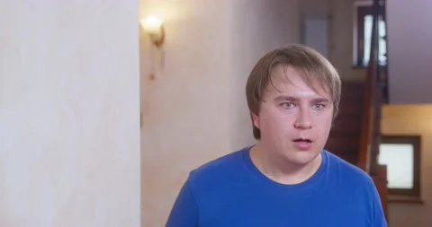 Young man in a panic runs into the room and turns his head from side to side Video stock 168778419