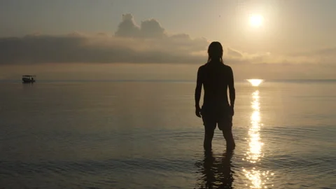 Young man on a paradise beach at dawn Stock Footage 130665522