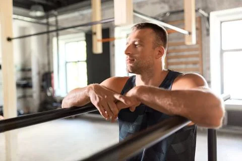 Young man at parallel bars in gym Stock Photos