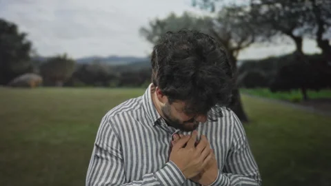 Young man in park experiencing chest pain, indicating heart attack, with ha.. Stock Footage 309891356