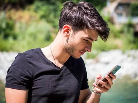 Young man in park using cell phone Stock Photos