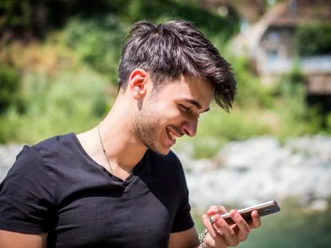 Young man in park using cell phone Stock Photos
