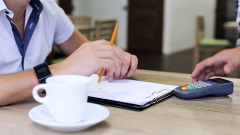A young man pays with a smart clock and terminal Stock Footage 80456758