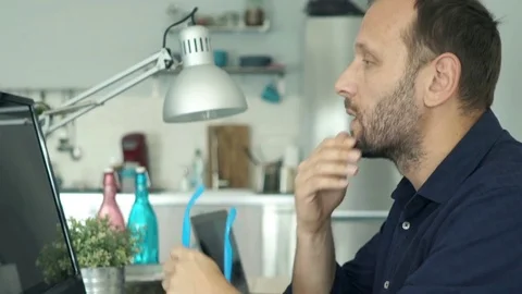 Young man with pc computer thinking, truing to solve problem at home Stockbeeldmateriaal 76486941
