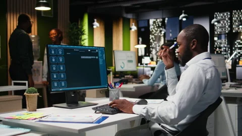 Young man PC user interacting with AI chat system on pc at office late at night Stock Footage 318500056