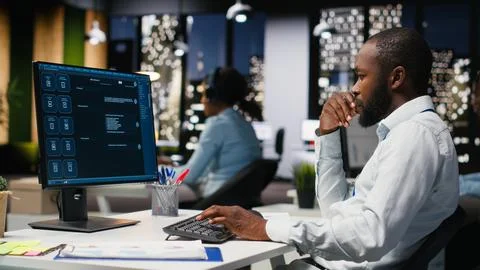 Young man PC user interacting with AI chat system on pc at office late at night Stock Photos