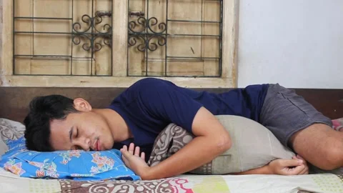 Young man peacefully sleeping on bed Stock Footage 320250683