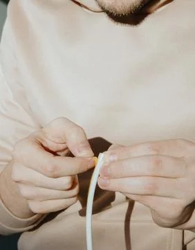 A young man peels off the protective layer from the rubber profile. Stock Photos