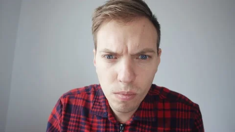 The young man peers at the screen. View from the laptop webcam. Vidéo 231574238