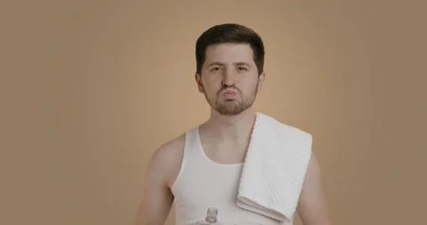 Young man with perfect clean skin wears white tank top, rinses mouth with Stock Footage 222004012