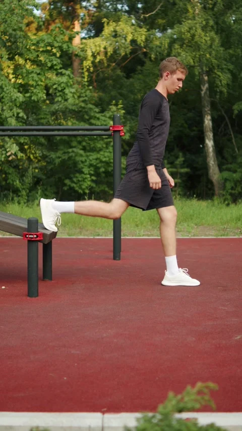 Young man performing a Bulgarian split squat with his back foot elevated on.. Stock-Footage 341728409