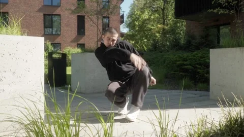 Young man performing dynamic breakdance moves in urban outdoor setting Stock Footage 283990218