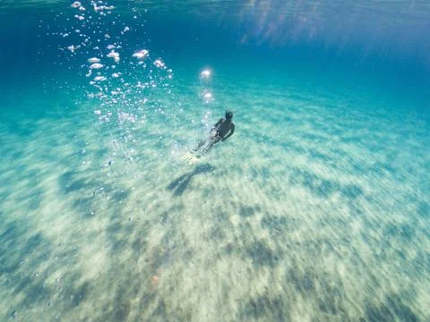 Young man performing an immersion in the turquoise sea. Man diving on the sea Stock Photos