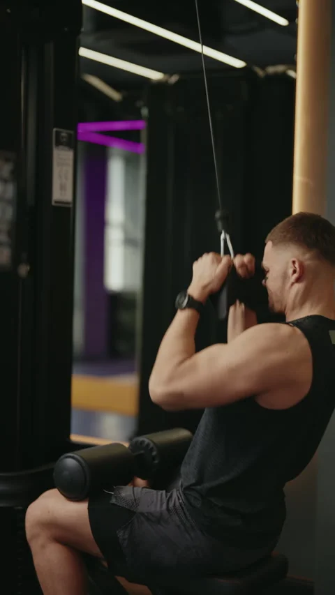 Young Man Performing Lat Pulldowns in a Modern Gym Stock Footage 313750827