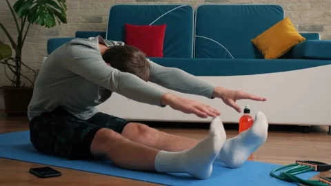Young man performing stretch exercise at home. Stock Footage 144490477
