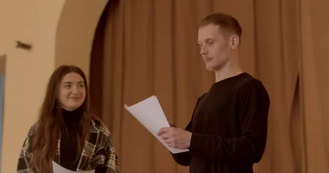 Young man performs a dramatic reading of a literary piece from a script on stage Stock Footage 268109799
