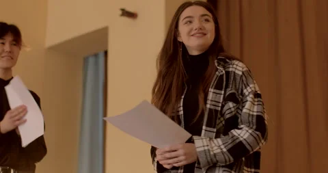 Young man performs a dramatic reading of a literary piece from a script on stage Stock Footage 271085437