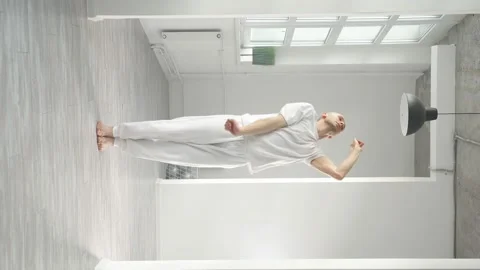 Young man performs elements of modern dance from a white studio Video stock 159855509