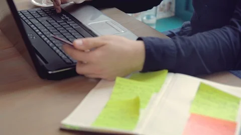 A young man performs an online payment on a portable computer Stock Footage 90818414