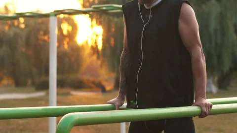 Young man performs a power Exercise On Uneven Bars. Stock Footage 79030603