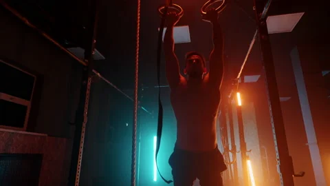 Young man performs pull-ups on gymnastic rings crossfit training day training Video stock 170612850