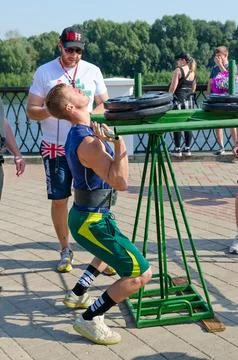 Young man performs Viking Press exercise during strength competition Stock Photos