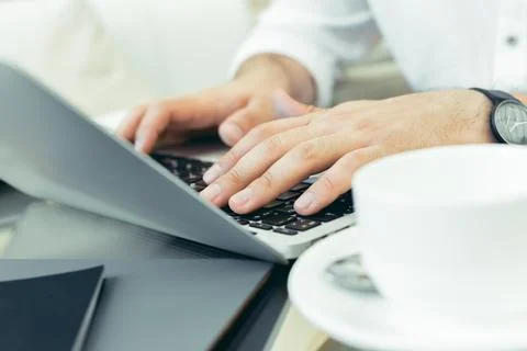 Young man performs work on a laptop Stock Photos
