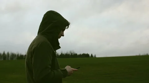 Young man with phone in the field Stock Footage 63849199