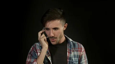 Young man on the phone. Guy holding smartphone and smiling. Flirting. Stock Footage 80303609