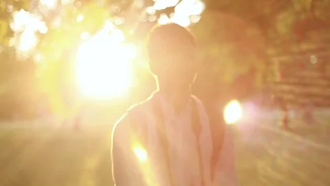 A young man photographing in a park during sunset Stock Footage 80670155