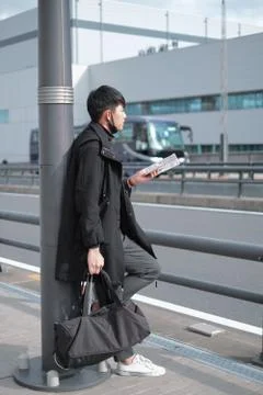 Young man picked up the map to see and wait for bus and taxi to travel in city Foto stock