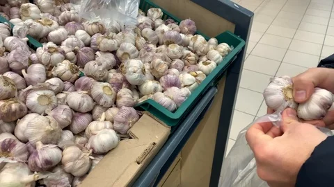 Young man picks up garlic in a plastic bag Video stock 120324005